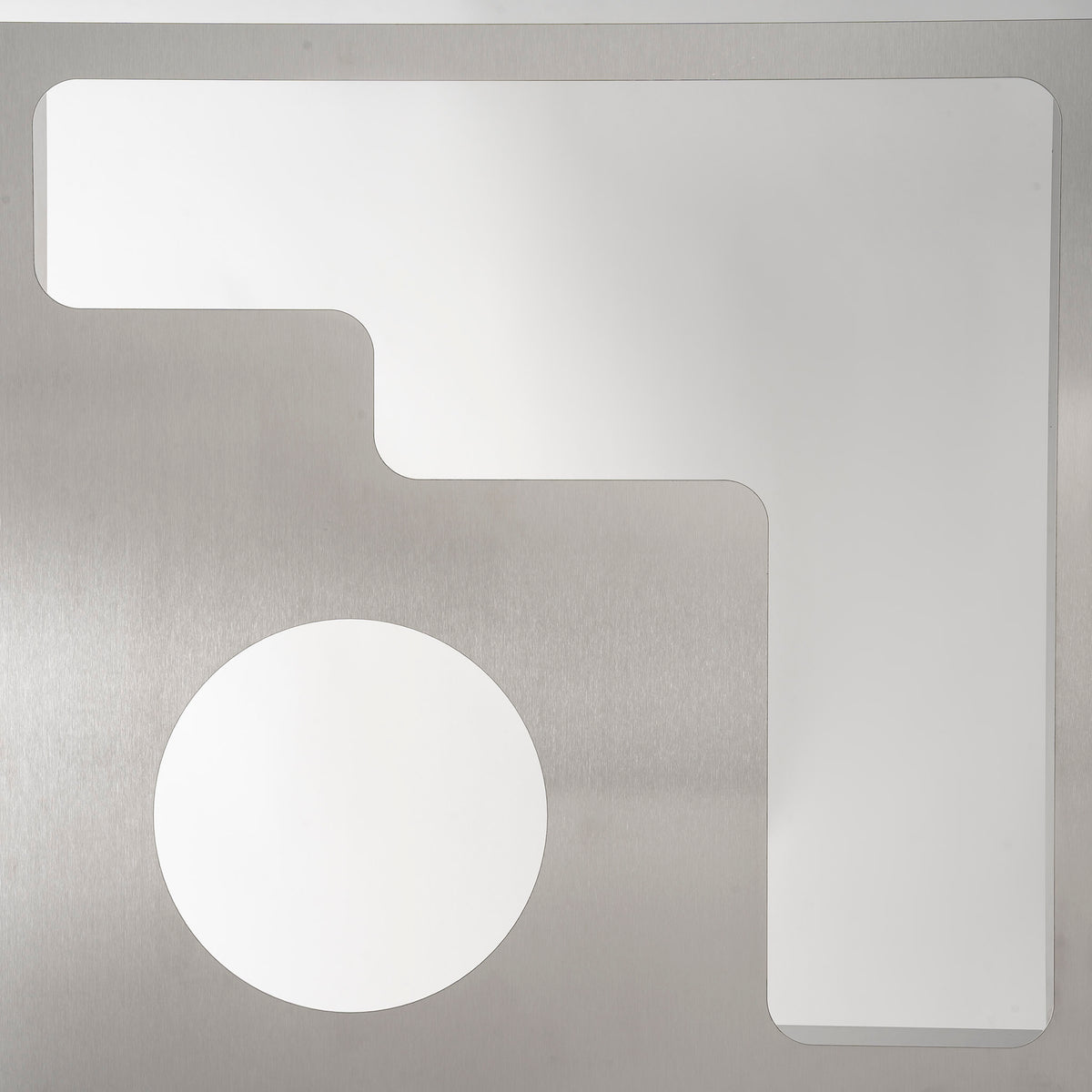 Claustra en aluminium brossé perforé, travail français contemporain — détail d'un cercle et d'un angle arrondi