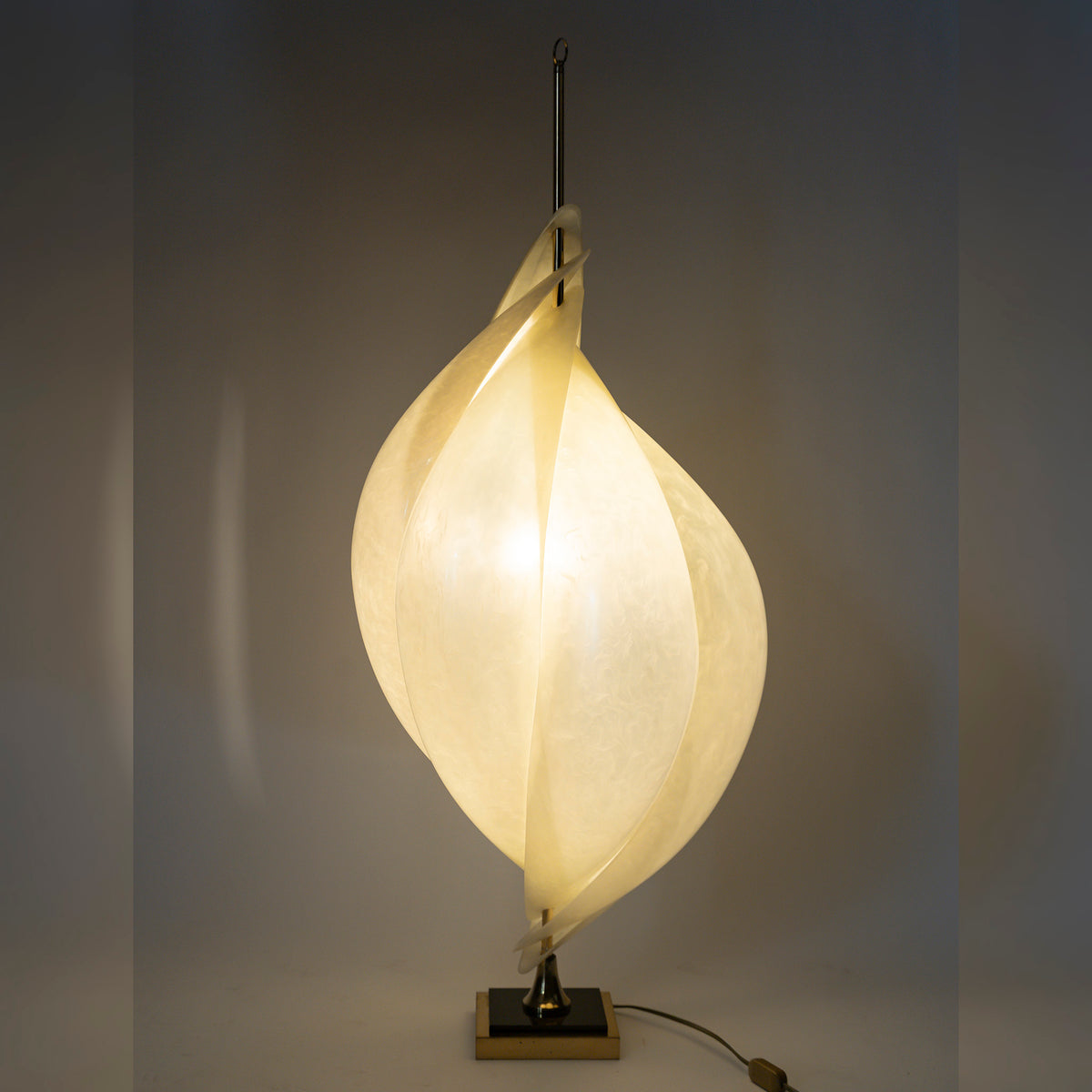 Lampe Coquillage de la Maison Rougier, méthacrylate nacré et laiton — allumée, la lumière traverse la matière