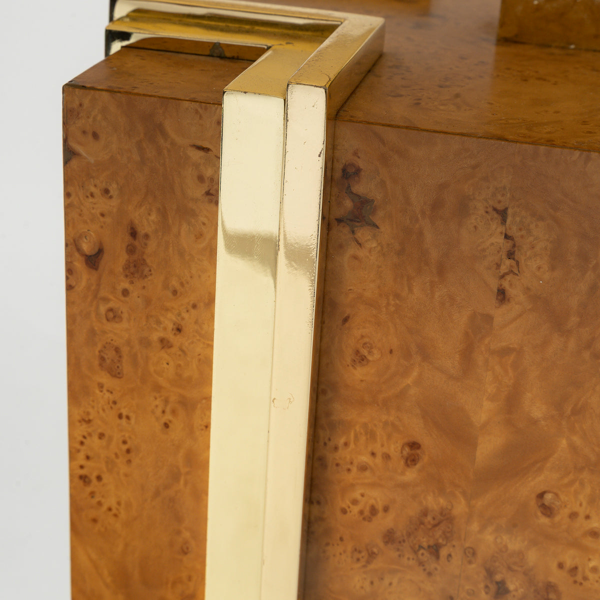 Détail de l'angle en laiton sur la loupe d'orme